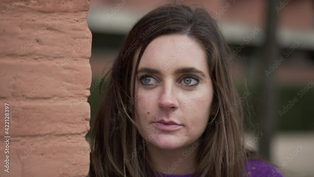 Young woman portrait face close-up standing outside looking at camera Young woman portrait face close-up standing outside looking at camera