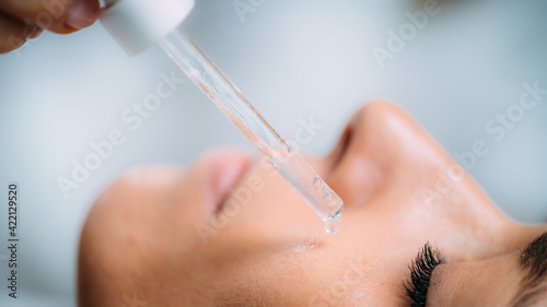 Cosmetician Applying Hyaluronic Acid Serum on Woman’s Face photo