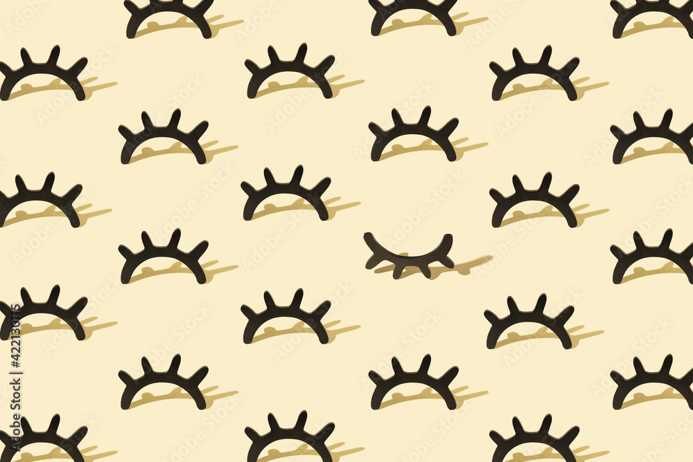 Fototapeta premium Creative pattern with wooden eyelashes on a pastel yellow background. Minimalist concept. Isometric layout.