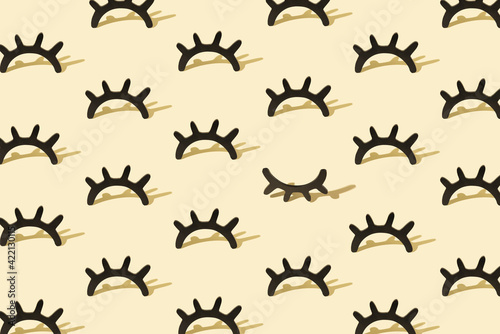 Creative pattern with wooden eyelashes on a pastel yellow background. Minimalist concept. Isometric layout. © Nemo Family
