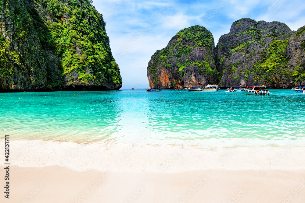 Beautiful beach with thai traditional wooden longtail boat and blue sky in Maya bay, Thailand.
