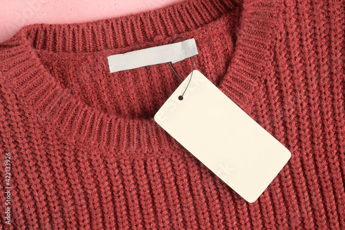 Mockup of a label and an inner label on the neck of a pretty red wool sweater. Blank space to place a logo, text or image