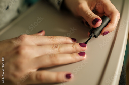 Close up woman painting her nails with polish.