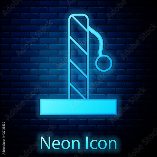 Glowing neon Cat scratching post with toy icon isolated on brick wall background. Vector
