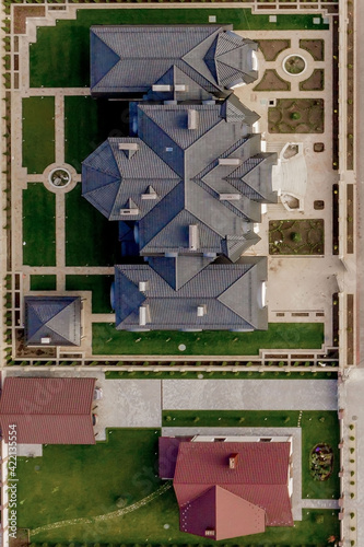 Aerial top view of a house with paved yard with green grass lawn with concrete foundation floor