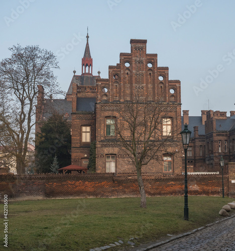 Czech Republic, Prague, February 23, 2021: View of building of Maternity Hospital Apolinar from Apolinarska street. A neogothic red brick facade complex from 19th century in Prague center, golden hour photo