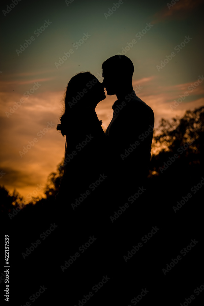 Silhouette of enamored man and woman at sunset.