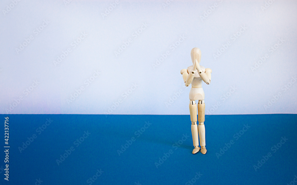 Prayer symbol. Wooden model of a human. Space for your inscription. Copy space. Beautiful blue table, white background. Religion, prayer concept. Prayer symbol. Wooden model of a human. Space for your inscription. Copy space. Beautiful blue table, white background. Religion, prayer concept.