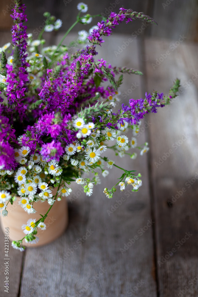 A bouquet of wild flowers. Summer wild flower. Wooden background and table. Place for text. Small Phalacrol and Veronica spicata. Copy space A bouquet of wild flowers. Summer wild flower. Wooden background and table. Place for text. Small Phalacrol and Veronica spicata. Copy space