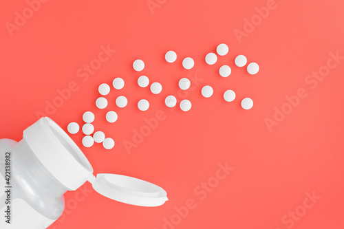 topview of methyl folate tablets flying from the jar. dietary concept. dietary supplement close-up