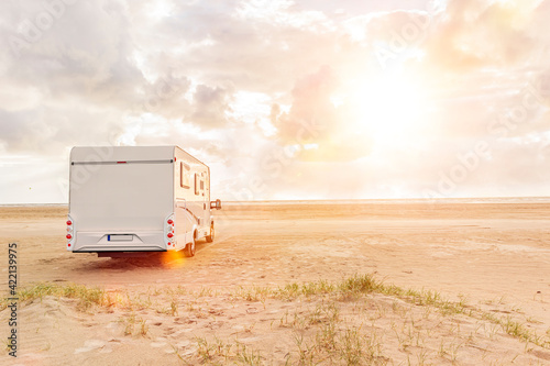 Wohnmobil auf einem Sandstrand am Meer