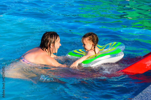 Playful children in the children's pool, happy children bathe with an inflatable circle.