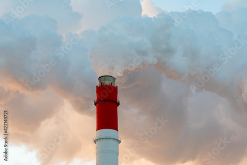 Air pollution by harmful emissions. Pipes with smoke on the background of a blue sk