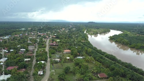 Small town surrounded by a river in a green plantation photo