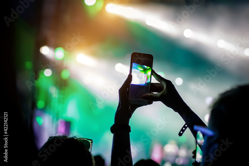 Concert visitor shoots video on a smartphone. photo