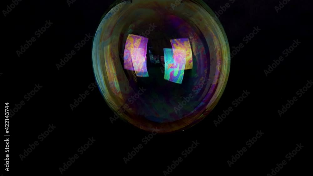 large soap bubble isolated on black background slow motion