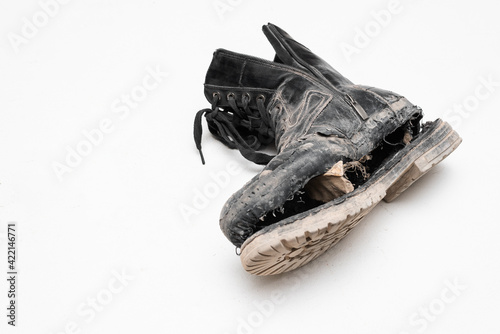 Old torn men boots shoes in a man hands on a white background.