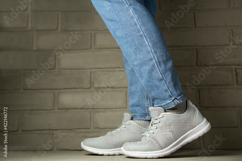 Female leg in jeans and sneakers, copy space template.