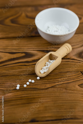 Homeopathy alternative medicine eco concept - classical homeopathy pills. Homeopathic globules on wooden background. 