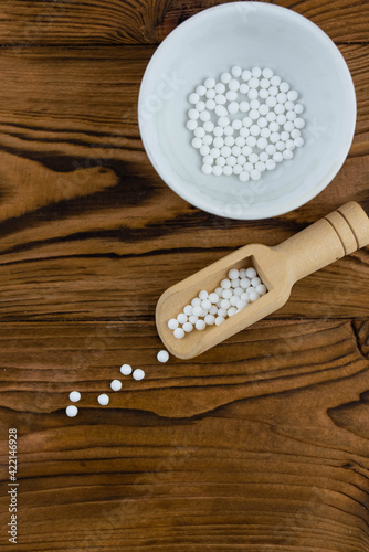Homeopathy alternative medicine eco concept - classical homeopathy pills. Homeopathic globules on wooden background. 