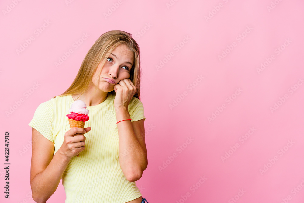 Young russian woman eating an ice cream isolated who feels sad and pensive, looking at copy space. Young russian woman eating an ice cream isolated who feels sad and pensive, looking at copy space.