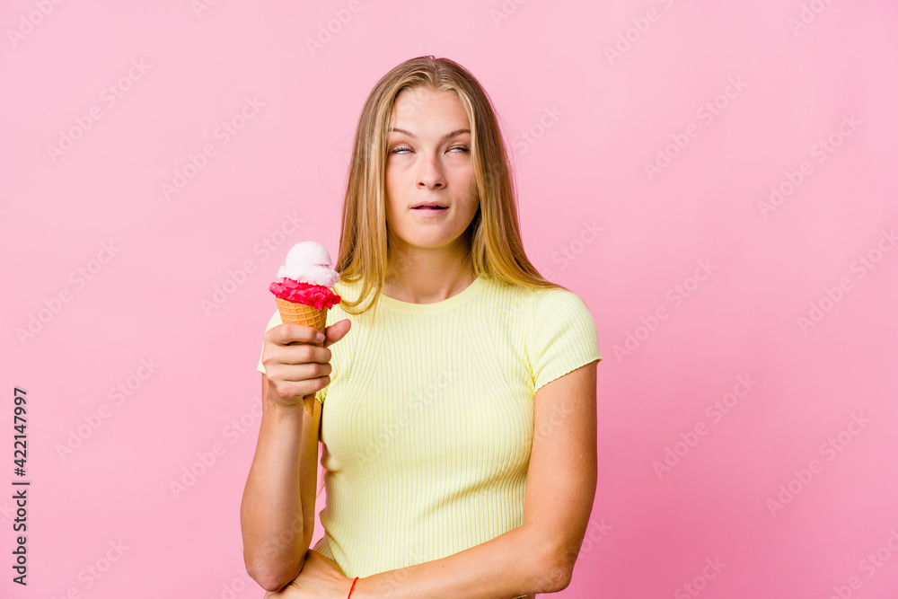 Young russian woman eating an ice cream isolated tired of a repetitive task. Young russian woman eating an ice cream isolated tired of a repetitive task.