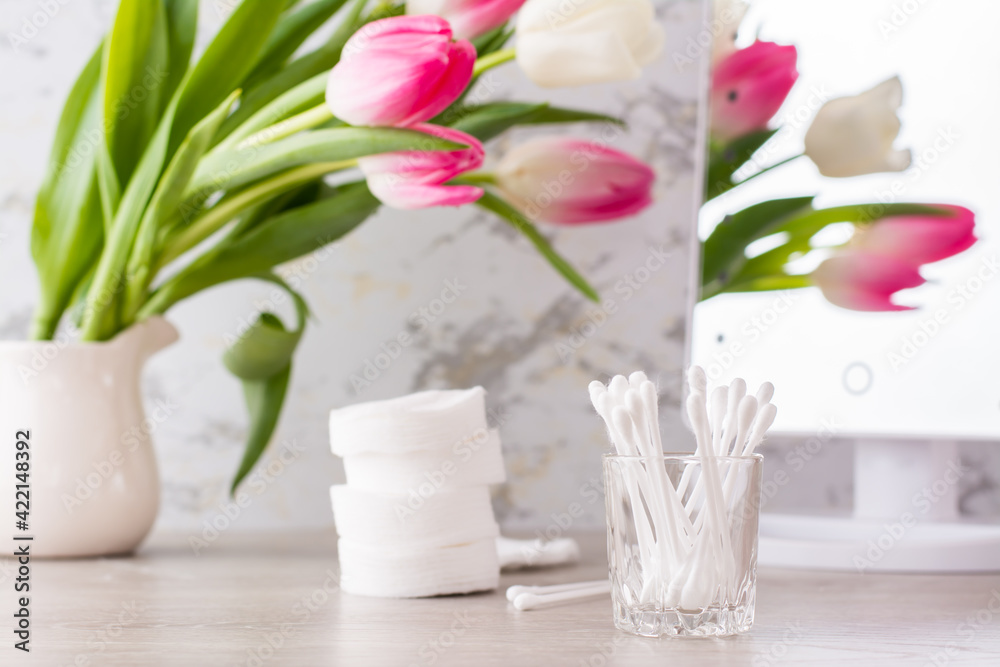 Personal hygiene, cleanliness and skin care. Cotton pads and swabs on the table in front of the mirror.