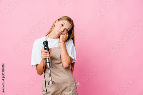 Young russian cook woman holding an electric mixer isolated who feels sad and pensive, looking at copy space.