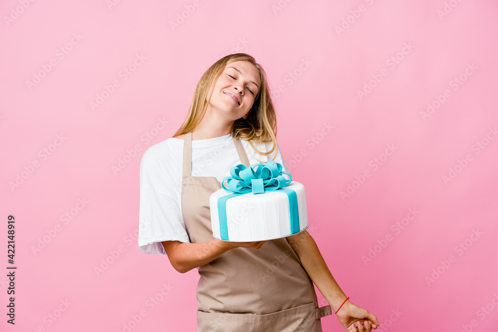 Young russian baker woman holding a delicious cake dancing and having fun. Young russian baker woman holding a delicious cake dancing and having fun.