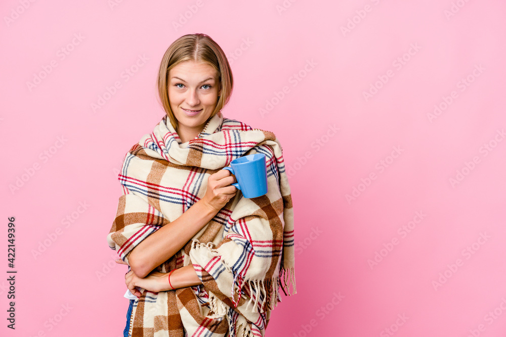 Young russian woman wrapped in a blanket drinking coffee smiling confident with crossed arms. Young russian woman wrapped in a blanket drinking coffee smiling confident with crossed arms.
