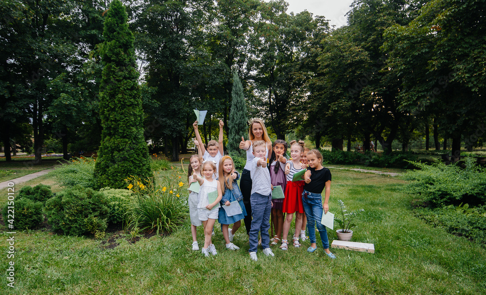Obraz premium A teacher teaches a class of children in an outdoor Park. Back to school, learning during the pandemic