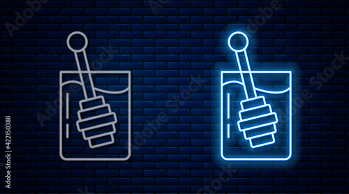 Glowing neon line Honey dipper stick icon isolated on brick wall background. Honey ladle. Vector