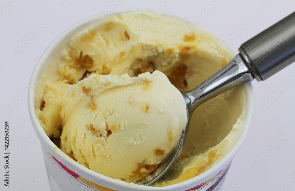 Delicious ice cream with macadamia nuts and caramel on a scoop