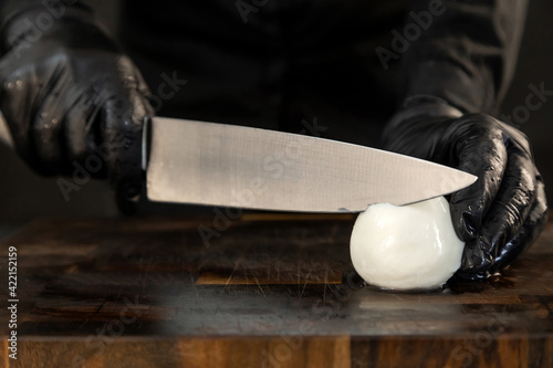 Obraz na płótnie Sliced mozzarella with knife on kitchen board w salonie