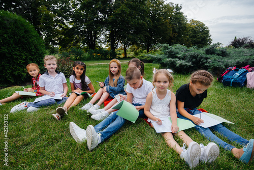 A teacher teaches a class of children in an outdoor Park. Back to school, learning during the pandemic