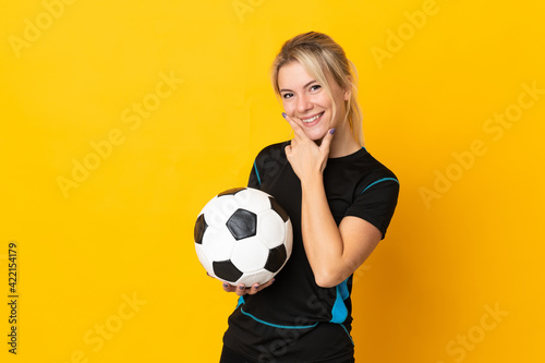 Young Russian football player woman isolated on yellow background happy and smiling © luismolinero
