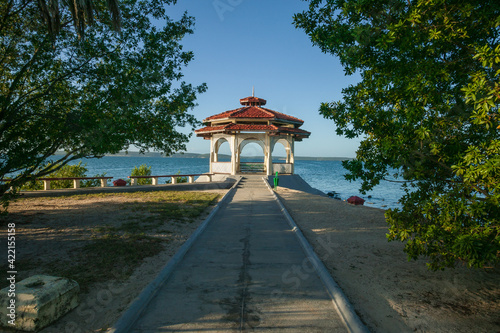 Inviting Cienfuegos Bay park with a sidewalk leading to picturesque waterfront red and white gazebo in the Punta Gorda neihborhood, Cienfuegos, Cuba. 