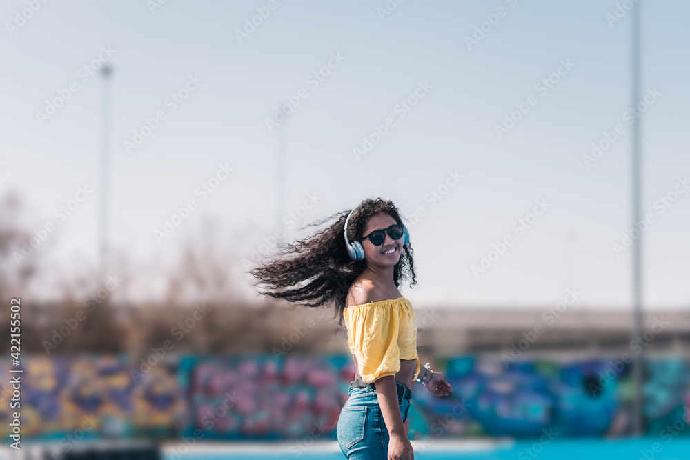 Young African American girl in a yellow t-shirt and sunglasses dancing.
