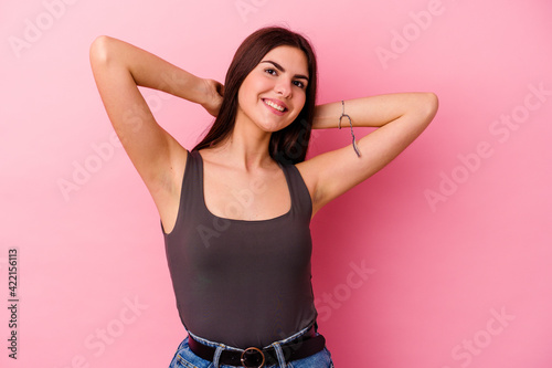 Young caucasian woman isolated on pink background stretching arms, relaxed position.