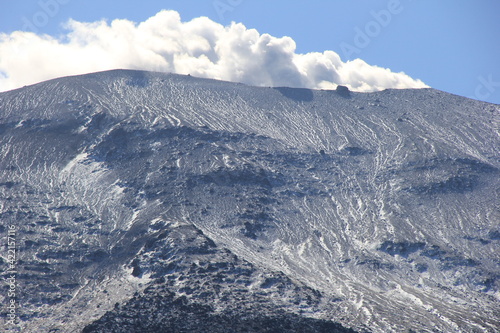 長野県と群馬県にまたがる、うっすらと雪が残っている浅間山 (稜線に見える突起物は、「千トン岩」と呼ばれる巨大な噴石)