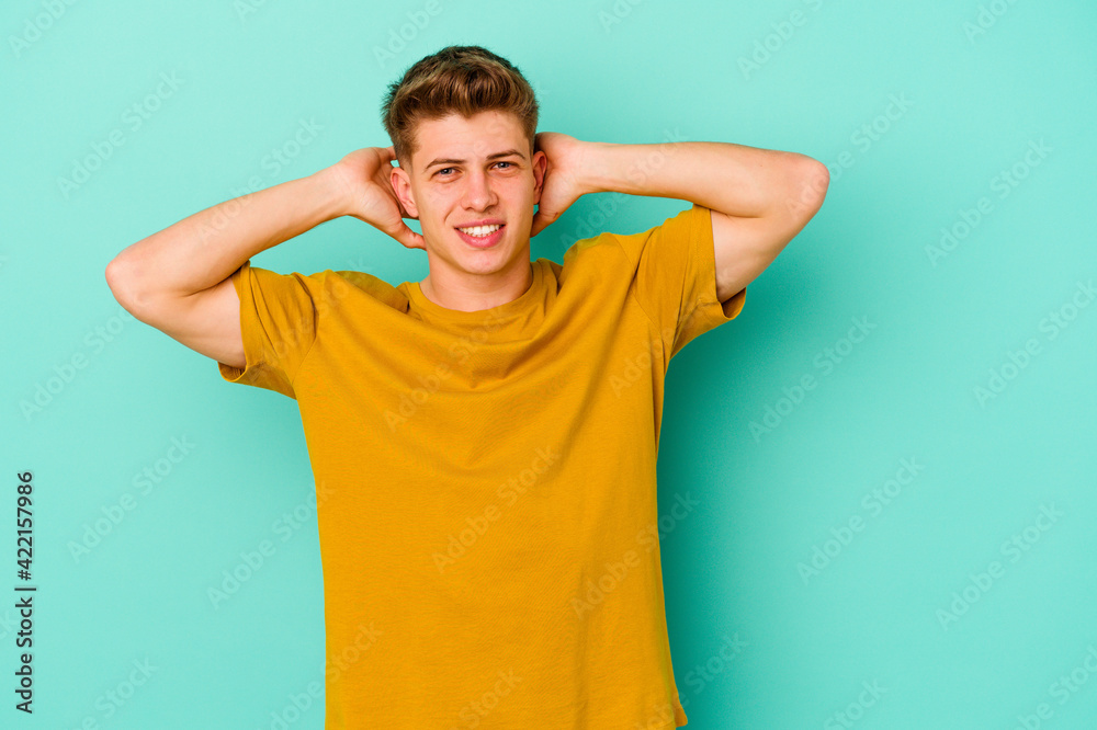 Young caucasian man isolated on blue background stretching arms, relaxed position. Young caucasian man isolated on blue background stretching arms, relaxed position.