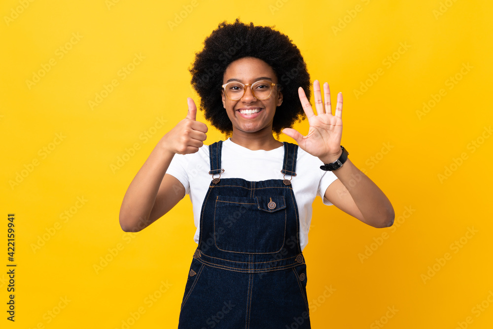 Fototapeta premium Young African American woman isolated on yellow background counting six with fingers