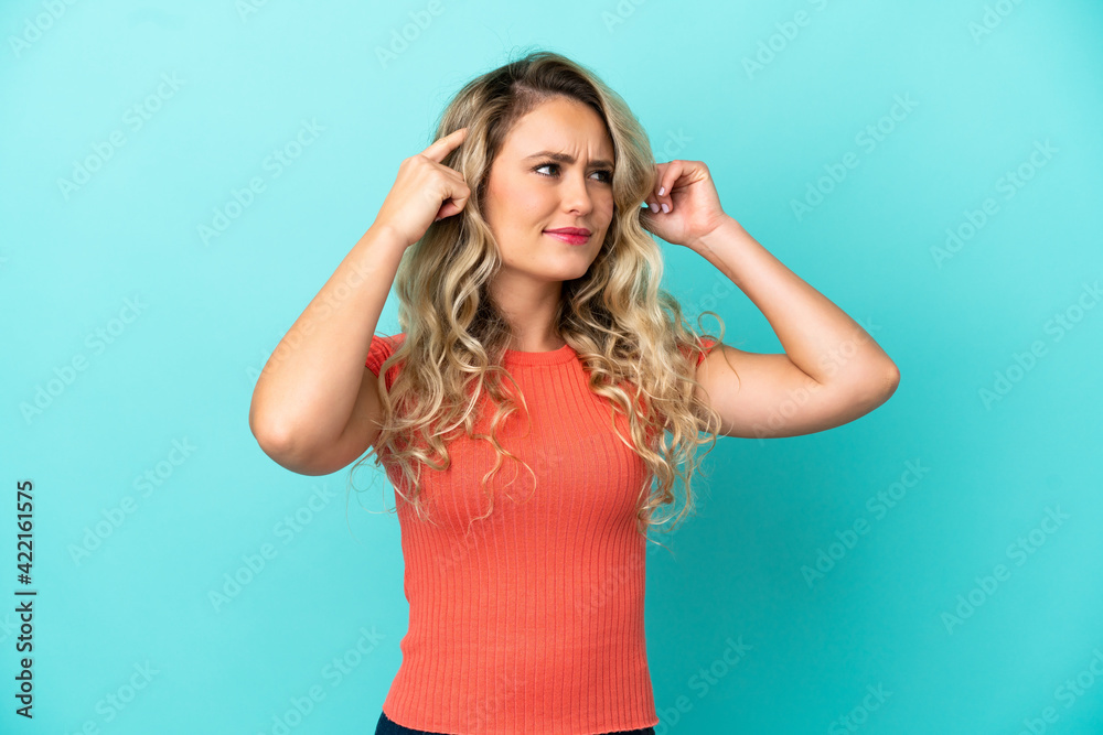Young Brazilian woman isolated on blue background having doubts and thinking