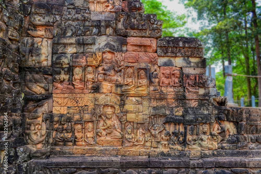 Banteay Srei - Cambodian temple dedicated to the Hindu god Shiva. Ancient Khmer ruins in the jungle. Red sandstone monument. Highly detailed bas-relief on a wall made of sandstone blocks