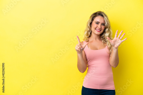 Young Brazilian woman isolated on yellow background counting seven with fingers