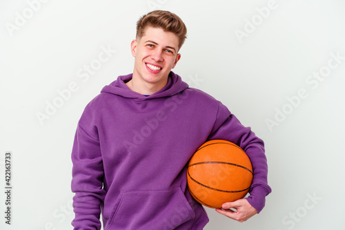 Young caucasian man playing basketball isolated background happy, smiling and cheerful.