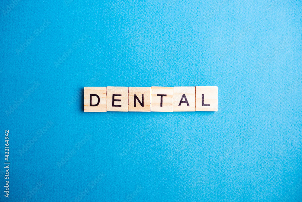 top view of alphabet blocks with letters on blue background. DENTAL lettering top view of alphabet blocks with letters on blue background. DENTAL lettering