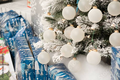 Christmas Holiday ornaments on a Christmas tree surrounded by wrapped gifts photo