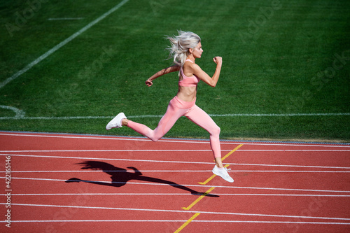 athletic lady compete in sprint. sport healthy lifestyle. fitness training outdoor. runner run fast