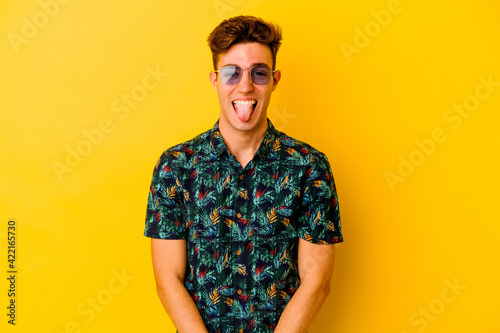 Wallpaper Mural Young caucasian man wearing a Hawaiian shirt isolated on yellow background funny and friendly sticking out tongue. Torontodigital.ca